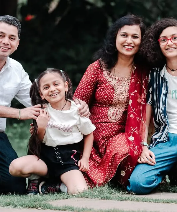 A beautiful family portrait session in a lush park, capturing the relaxed and joyful connection between parents and their children. My goal is to create these natural, happy memories for you to cherish.