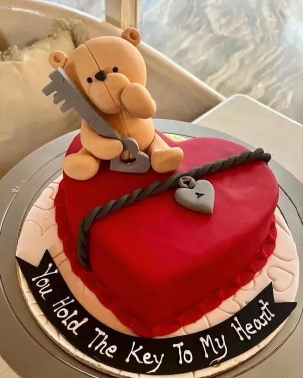 This heart-shaped Valentine's cake sends a clear message with a charming teddy bear holding the "key to my heart." The detailed fondant work makes it a memorable romantic gesture.