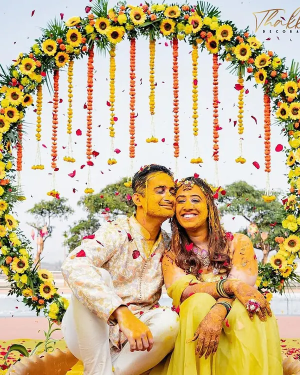 A perfect shot of the happy couple during their Haldi ceremony, framed by a circular backdrop of sunflowers and marigolds. I design these spaces to be both beautiful for the ceremony and perfect for photos you'll cherish forever.