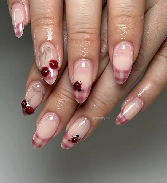 Loving the cherry trend. This cute set features a sheer base with a pink plaid French tip and tiny, detailed cherry and ladybug art.