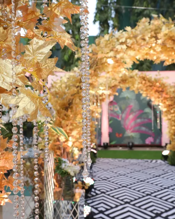 We created this enchanting golden forest entryway for a Sangeet night. The crystal strings and warm lights made guests feel like they were stepping into another world.