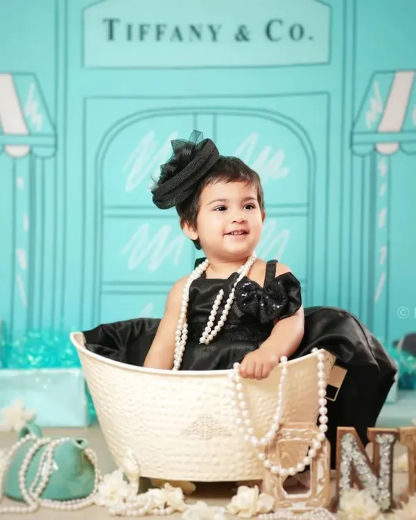 A glamorous first birthday shoot with our 'Tiffany & Co.' theme. The iconic blue backdrop and pearl accessories create a chic and stylish portrait.