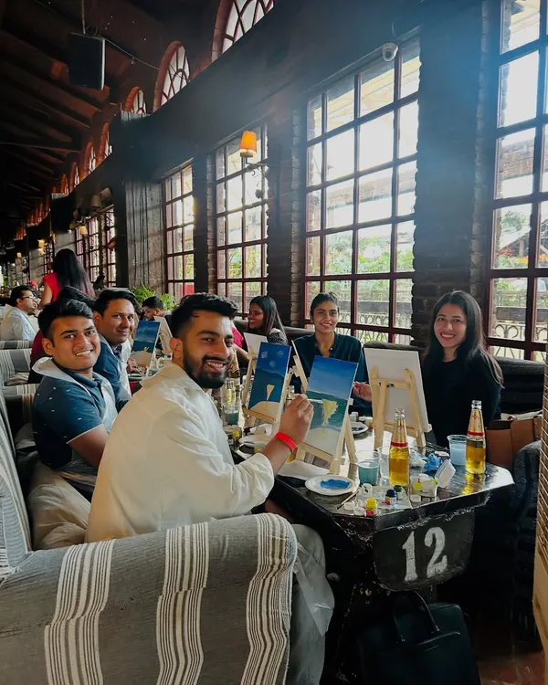 A happy group of friends enjoying a sip and paint session. The combination of a relaxed cafe atmosphere, drinks, and creativity is a perfect recipe for a great time.