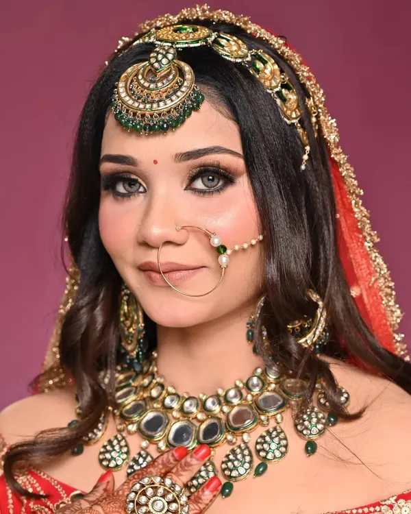 A close-up of a modern bridal look, featuring flawless HD makeup with dramatic golden glitter eyes and a soft, elegant hairstyle. This is the kind of perfection I aim for with every bride.