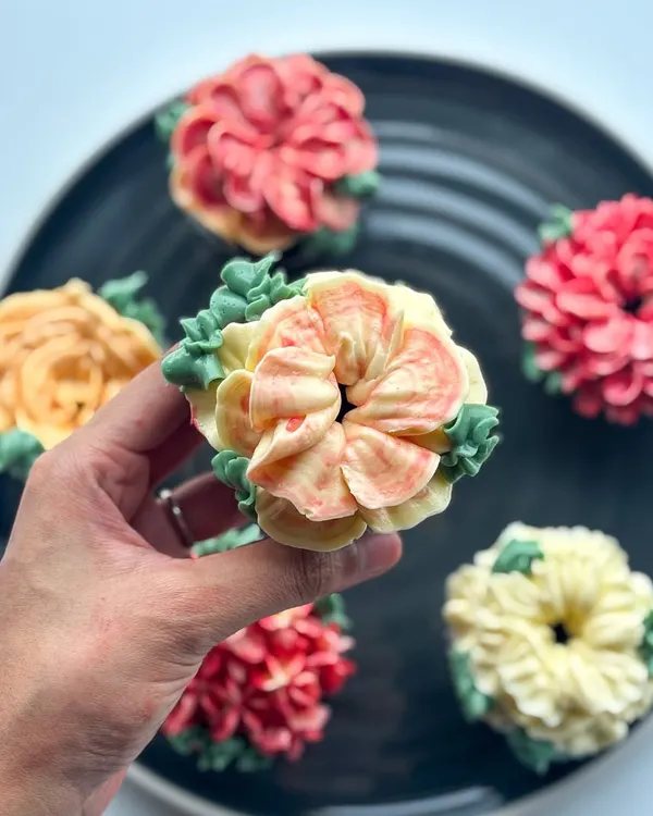 A closer look at my edible floral cupcakes. Each one is a mini work of art, with different flower designs like roses, dahlias, and succulents, all hand-piped with delicious buttercream in a variety of colors.