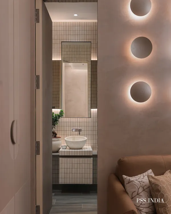 A peek into an ensuite bathroom that continues the story of the guest room. Minimalist tiles, a sculptural vessel sink, and a touch of greenery soften the modern lines and create a cohesive design experience.