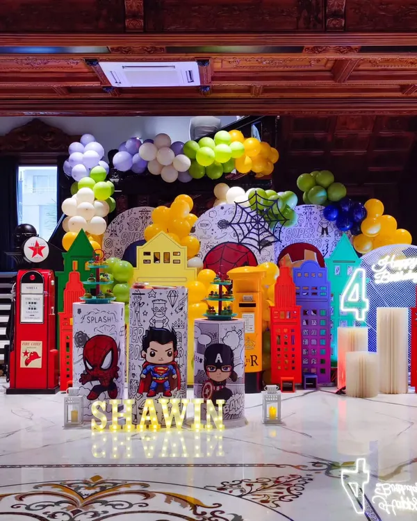 Assembling the ultimate superhero party. This setup features a cityscape backdrop with comic book elements and chibi versions of Superman, Captain America, and Spider-Man for a fun and vibrant birthday.