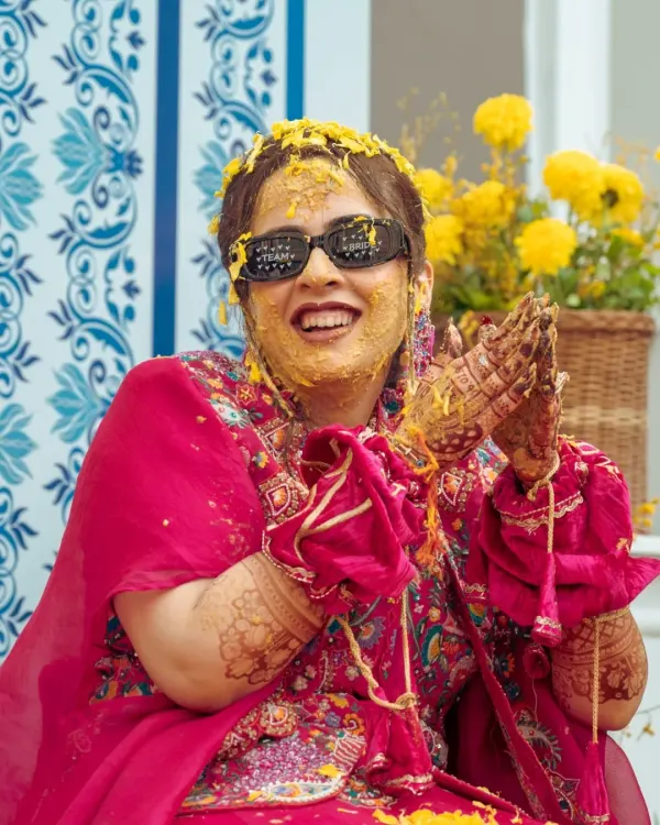 The pure joy of a haldi ceremony! This candid shot captures the bride's infectious laughter as she's covered in turmeric paste.