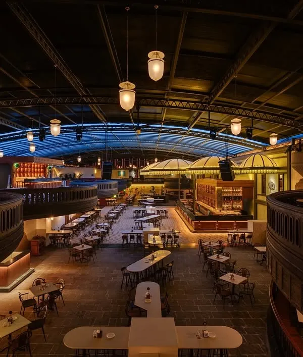 An overhead view of the entire Jollygunj space, showing the relationship between the different levels and seating zones. The design allows for both intimate corners and grand, open areas, unified by the warm, ambient lighting scheme.