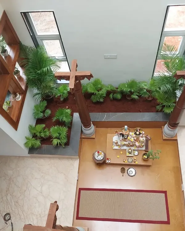 This top-down view shows how an indoor garden can transform a central courtyard or pooja area. The symmetrical design with lush palms brings life and serenity to the heart of the home.