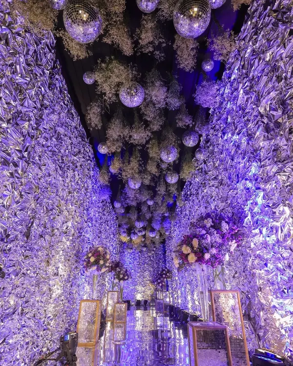 A breathtaking shot of the engagement party decor, featuring a ceiling filled with disco balls, flowers, and purple lighting. It's all about capturing the atmosphere.