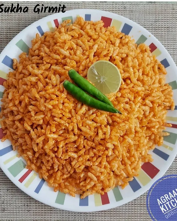 A plate of Sukha Girmit, a popular puffed rice snack from North Karnataka. It's tangy, spicy, and light, served here with fresh green chillies and a wedge of lime.