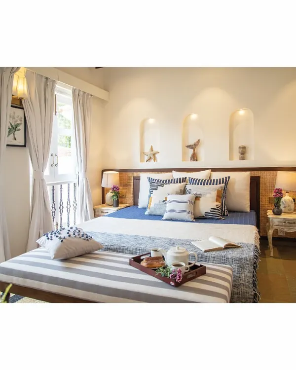 For this holiday home bedroom, the mood board was all about sun and waves. We used a cool palette of blues and whites, natural cane headboards, and striped fabrics to evoke a breezy, tropical feeling, perfect for a peaceful escape.