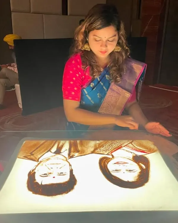 Performing live in my first Kanjivaram saree, creating a portrait for a special event. I love how traditional attire complements the cultural nature of my art.