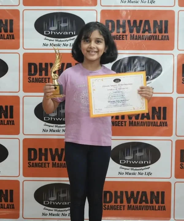A happy student with her award from the Dhwani Kala Mahotsav. This focus on personal growth is central to our wellness classes for kids and adults.
