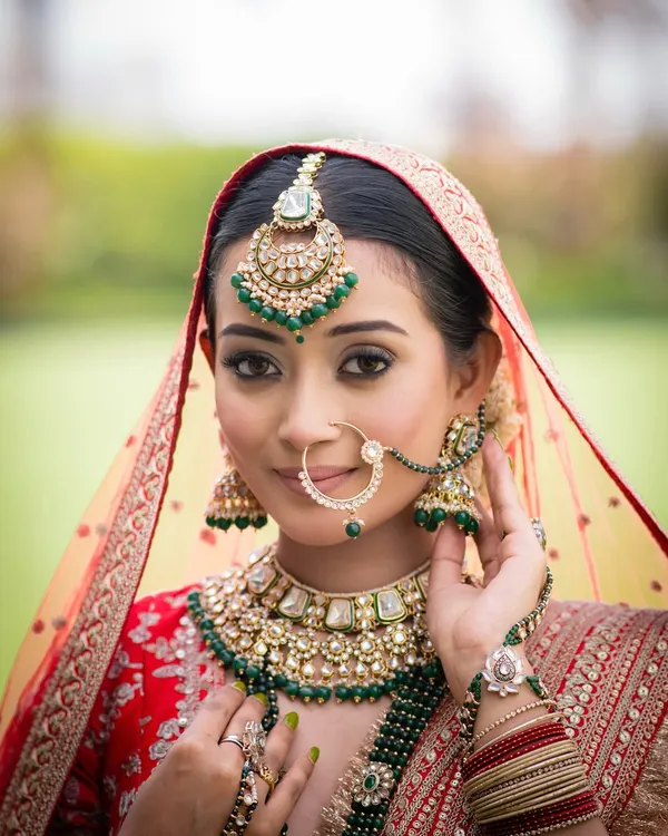 This is the essence of timeless bridal beauty. For this classic North Indian bridal look, I focused on creating soft, radiant skin that glows, paired with gentle yet defined eyes to complement her magnificent red lehenga and emerald kundan jewellery.