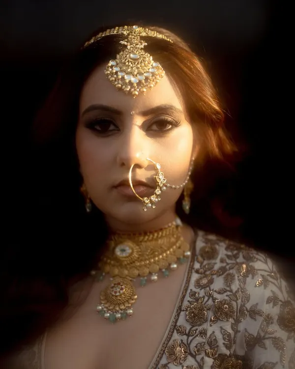 A powerful and artistic close-up of the bride. The dramatic lighting and her confident gaze create a portrait that is both beautiful and full of personality.