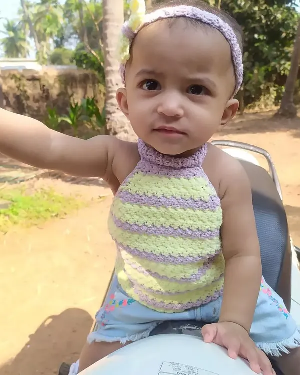 My daughter enjoying a sunny day in the Lavender Halter Top. This style is perfect for the beach or a playdate, made with soft, striped yarn that is gentle on the skin.