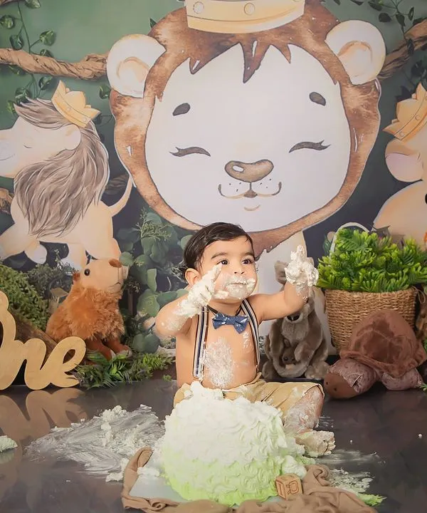 Hakuna Matata. This little one is having a wild time at his jungle-themed first birthday cake smash, surrounded by his favorite animal friends.