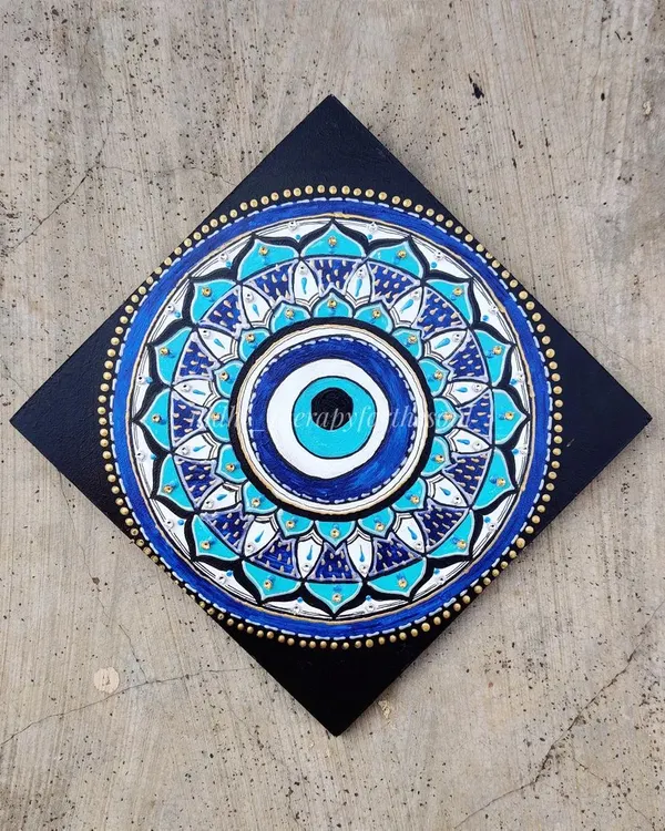My take on the 'Nazar' or evil eye, designed as a mandala. I used shades of blue and white with gold accents to create this protective and beautiful wall hanging.