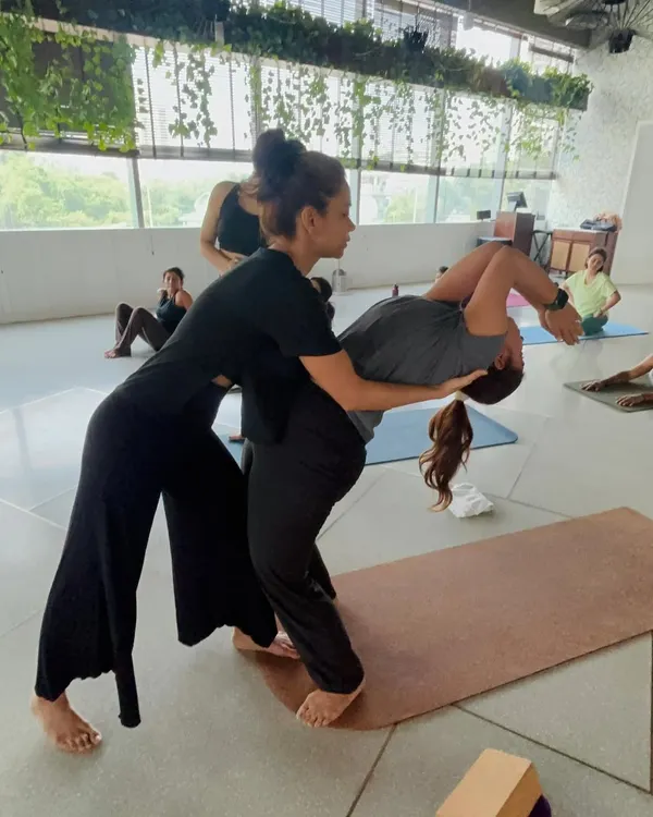 A hands-on adjustment during a deep backbend, helping the student find space and support in Urdhva Dhanurasana. My focus is always on using strength and breath, not just flexibility, to achieve depth safely.