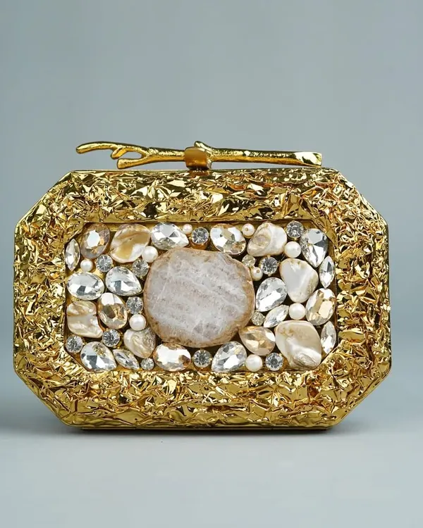 This is one of my most luxurious pieces, a handcrafted brass clutch with a stunning textured gold finish. It's adorned with a beautiful arrangement of natural and polished stones, making it a true statement accessory for any grand occasion.