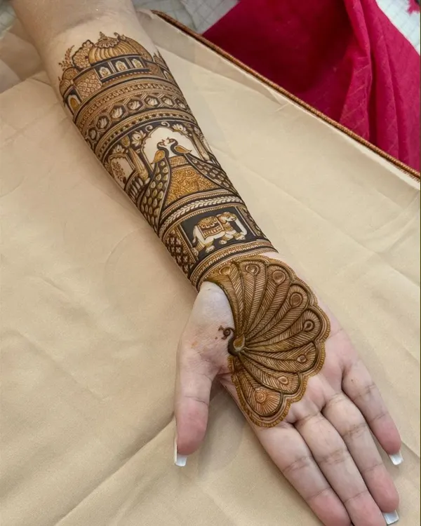 A unique design where the peacock's feather transforms into the full palm design. The arm features a traditional palace scene, creating a truly artistic piece.