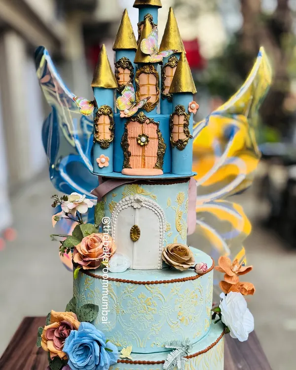 This enchanting blue castle cake is a true fairytale creation, complete with kinetic butterfly wings that seem to flutter. The intricate details and golden turrets make it a magical centerpiece.