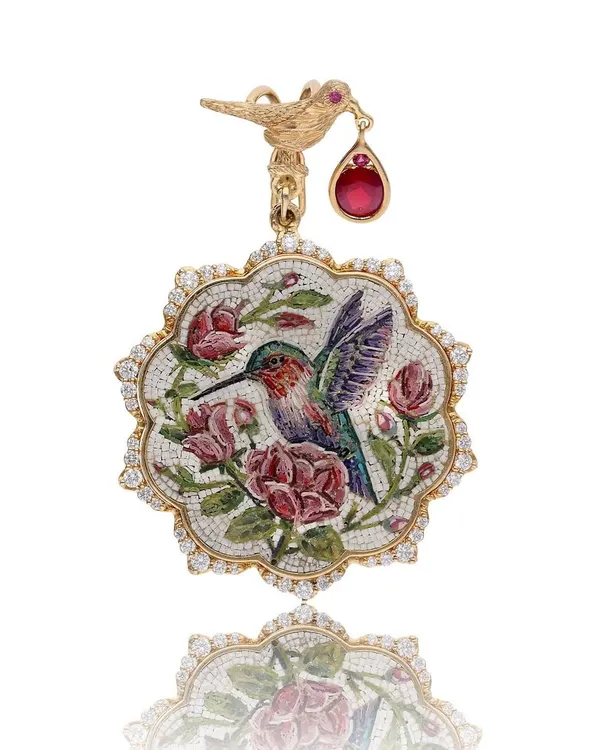 This hummingbird and roses pendant is a piece of my heart, handcrafted in 18k gold. It features a micromosaic scene surrounded by natural diamonds and a beautiful Mozambique ruby from Gemfields, capturing a fleeting moment of nature's poetry.