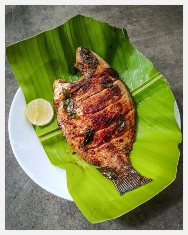 A whole Tawa Grilled Karimeen (Pearlspot) served on a banana leaf. I source this wild-caught fish from Kerala and cook it with a simple salt and chilli rub in coconut oil to let its delicate, natural flavour shine.