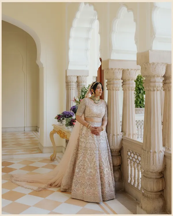 A bridal portrait in the serene, sunlit corridors of Rambagh Palace. The historic architecture provides a timeless frame for the bride's modern elegance.