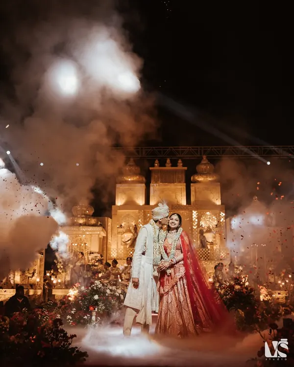 This is the moment that feels like a film. The world fades away, and under a shower of petals and a haze of celebratory smoke, there are only two people. We live to capture these grand, breathtaking scenes where love feels larger than life itself.