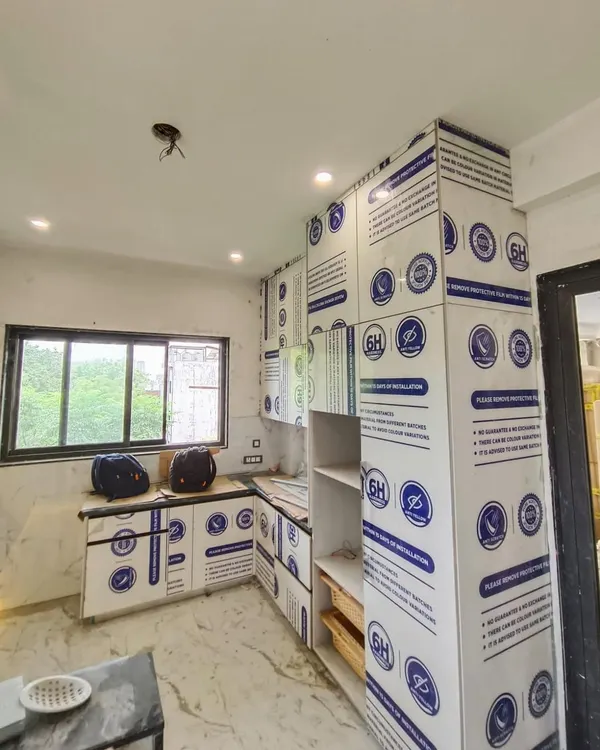 An ongoing installation in Gurgaon. This image shows the kitchen cabinets with their protective film still on, ensuring the high-gloss Italian acrylic shutters remain scratch-free until the final handover.