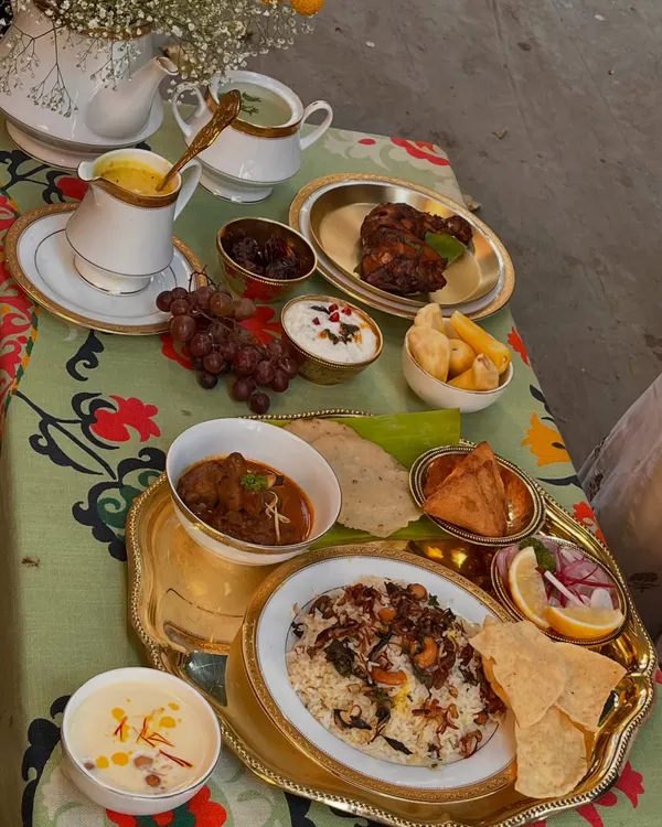 Our Eid table tells a tale from Arab sails to Malabar shores. This grand spread features fragrant biryani, rich mutton curry, grilled chicken, fresh fruits, and sweet payasam, a true feast for the senses.