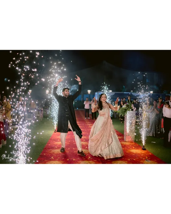 A grand entrance for a magical Sangeet night. Zaee and Kartik make their way down a red carpet lined with sparklers, a perfect start to an evening of celebration.