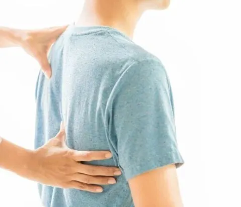 Back pain can stem from many causes, including poor posture, injury, or degenerative conditions. Here, a therapist assesses a patient's back, the first step toward creating a personalized relief plan.