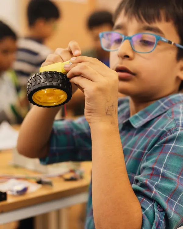 A young innovator completely focused on his robotics project. Here, children learn to build and tinker with autobots, developing logical thinking and problem-solving skills.