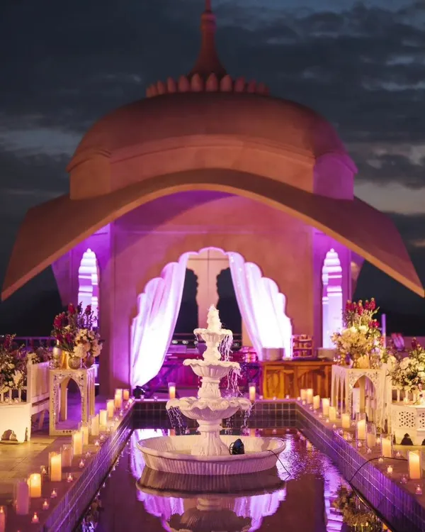The stunning rooftop setup for a Sufi night at the Fairmont Jaipur. The combination of the architectural dome, purple uplighting, and candlelit water feature created a truly magical and romantic ambiance.