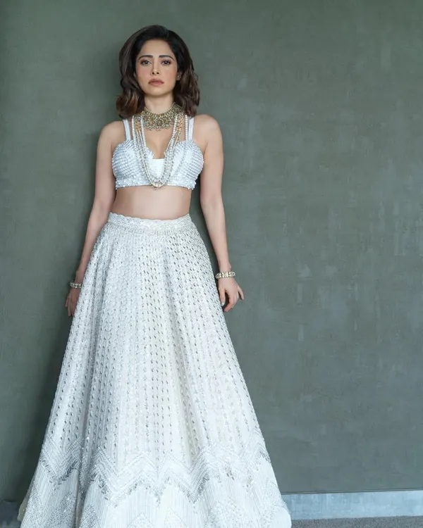I styled Nushrratt Bharuccha in this ethereal ivory lehenga by Disha Patil for a wedding. The layered pearl necklaces add a touch of modern royalty, making it a standout look for a wedding guest.