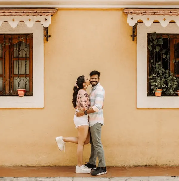 A stolen, joyful kiss against the warm, sunlit walls of Goa. We believe the most beautiful moments are the unscripted ones, full of pure happiness.