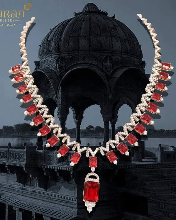 A fiery and dramatic statement necklace. This piece features brilliant red stones set in a zigzag pattern of sparkling zircons, designed to capture attention and make a bold style statement.