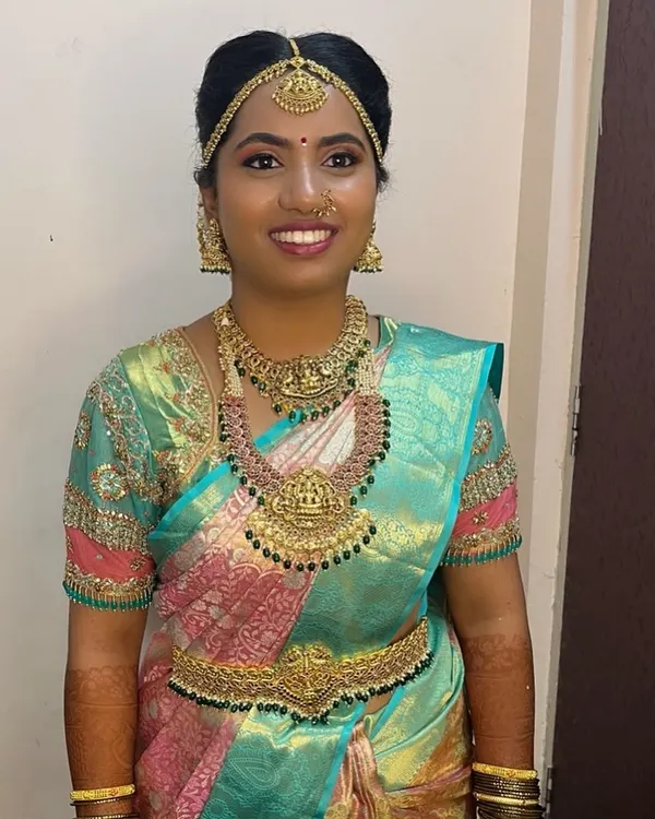 A happy client looking radiant on her wedding day in a complete South Indian temple jewellery set. The set includes a choker, Lakshmi haar, and matching vaddanam.