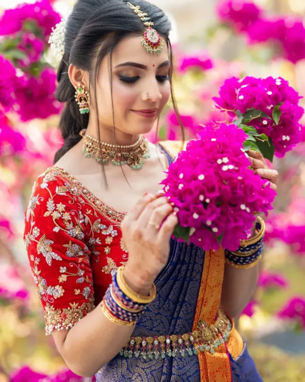 A beautiful engagement look. The bride is surrounded by bright pink bougainvillea, and her makeup is kept fresh and romantic to match.