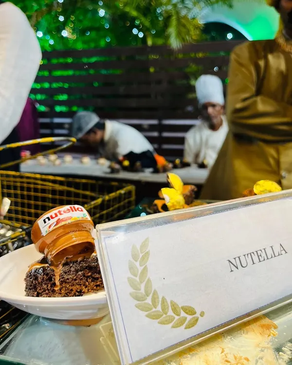 A decadent plated dessert featuring a rich chocolate brownie topped with a mini jar of Nutella. This playful and indulgent creation is a guaranteed crowd-pleaser for guests of all ages.