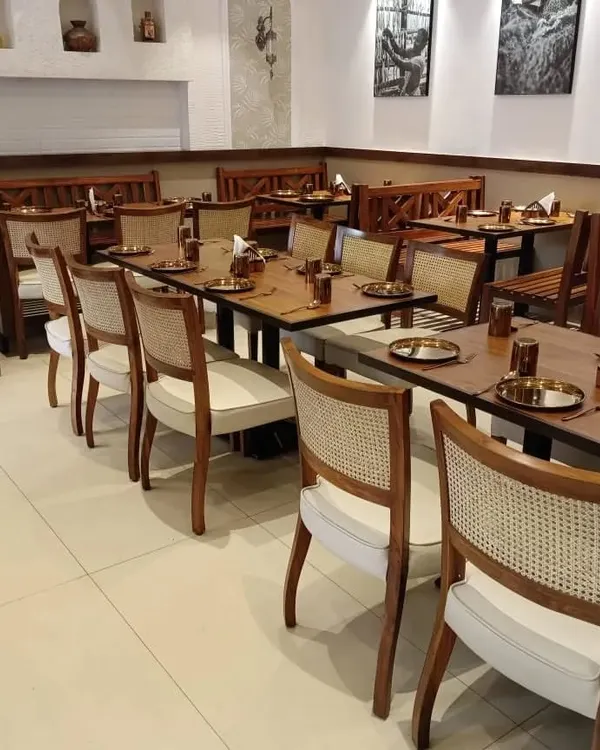 A wide view of the dining area at 'The Big Fish & Co.' restaurant in Dadar. I supplied all the furniture, including the cane-back chairs, solid wood tables, and benches, to create a cohesive and inviting atmosphere for diners.