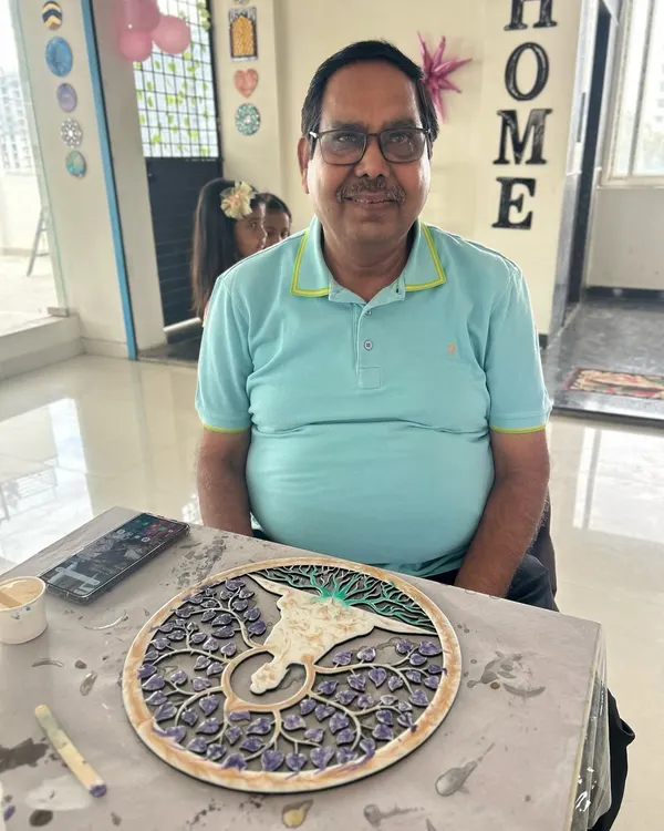 A happy participant with his finished 'Tree of Life' texture art piece.