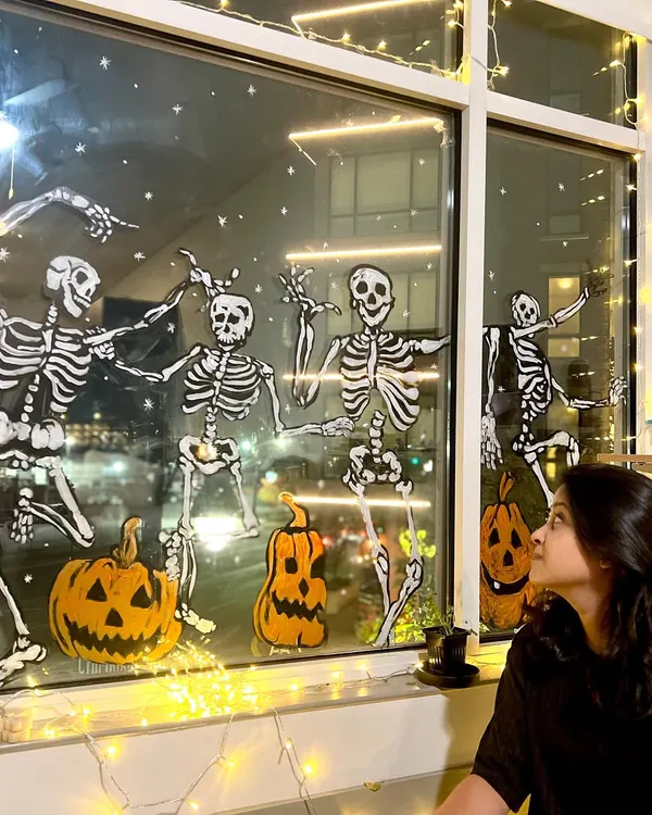 Getting into the Halloween spirit with a full-window painting of dancing skeletons and jack-o'-lanterns at our New Jersey studio.
