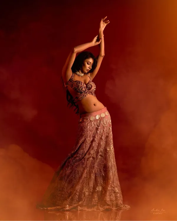 This shot is pure art and movement. I used smoke and warm, dramatic lighting to create an ethereal atmosphere, capturing the model in a graceful dance-like pose that highlights the flow of her lehenga.