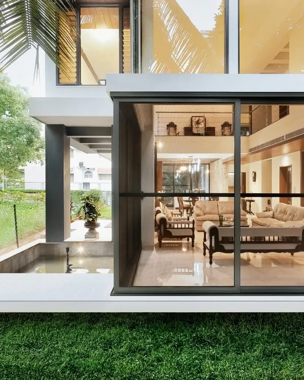 This design, named "Synthesis," perfectly illustrates our philosophy of blurring boundaries. The living room's floor-to-ceiling glass walls slide open to connect directly with the lawn and an outdoor water feature.