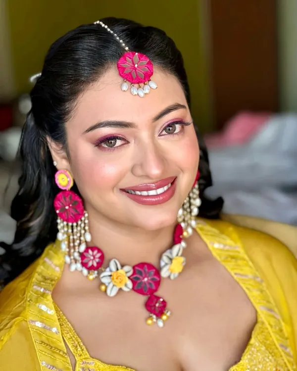 A soft pink finish for a Haldi ceremony. I paired a bright pink eyeshadow and lip with the bride's yellow outfit and floral jewelry for a fun, colorful, and festive look.